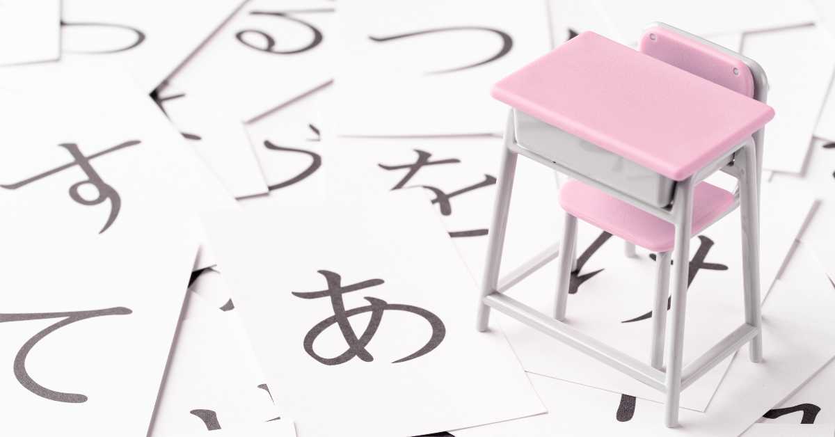 Image of Japanese hiragana flashcards on the floor with a miniature pink studying desk toy
